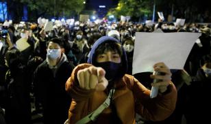 People hold white sheets of paper in protest over COVID-19 restrictions in Beijing on Nov. 27, 2022. Crowds had gathered for a vigil honoring the victims of a fire in Urumqi, which took place during COVID-19- related lockdowns in China. (Image credit: Reuters/Thomas Peter)