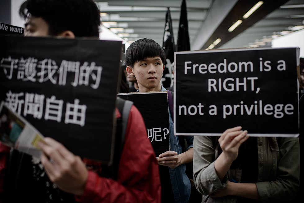 protester holds sign that says freedom is a right not a privilege hong kong china