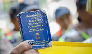 Detail of a copy of the Constitution of Venezuela. In the hands of a demonstrator against the government of Nicolás Maduro. Venezuela. Decmeber 2016. Editorial credit: StringerAL / Shutterstock.com