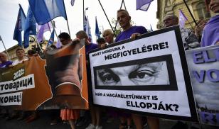 A man holds a poster showing Hungary's Prime Minister Viktor Orban reading: " We say no to your observation! Do you want me to steal our privacy?" during a protest against the Hungarian government for using Pegasus spyware to monitor journalists,
