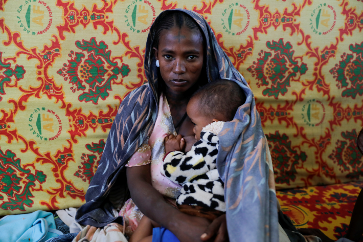 FIW2023_EthopiaTigray A woman holds an infant inside the Adiha secondary school, which was turned into a temporary shelter for people displaced by conflict, in the city of Mekelle, Tigray region, Ethiopia